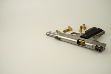 Hand gun and .45acp caliber ammunition. On a white background