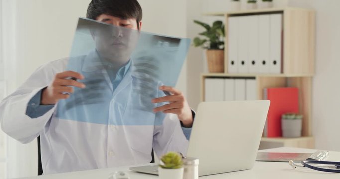 Male doctor intellectual healthcare professionals with white labcoat, looking at full body x-ray radiographic image. Health care and medical concept.