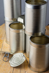 Top view of empty stacked cans for recycling, on rustic wooden table, vertical