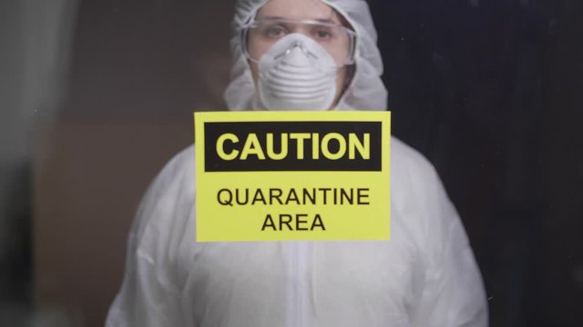 woman in protective suit in quarantine zone. Coronovirus and isolation concept