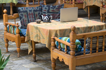 Traditional uzbek table with teapot, teacup (piala) and laptop. Uzbekistan, Central Asia.