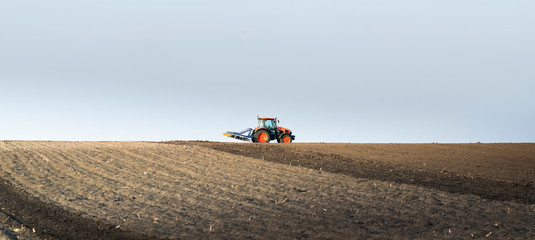 Tractor is preparing the land at dusk