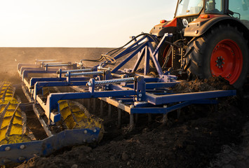 Tractor is preparing the land at dusk