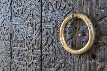 Old wooden door (with copper handle) of Mohammed Rakhim Khan Madrasah.  Khiva, Uzbekistan.