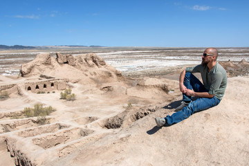 Naklejka premium European tourist in Toprak-Kala fortress (ancient Capital of Khorezm, one of the most popular touristic attraction in the country). Karakalpakstan, Uzbekistan, Central Asia.
