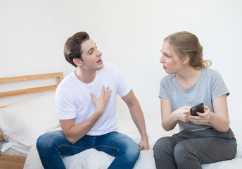 caucasian unhappy man and woman have argument on smart mobile phone in home, relationship social...