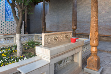 Obraz premium Inner courtyard with basin for ritual purification (ablution) and old wooden pillars. Pahlavon Mahmud mausoleum, Khiva, Uzbekistan, Central Asia.