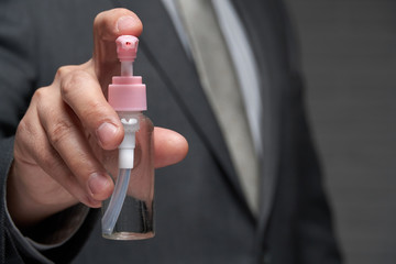 a man demonstrates a protective face mask for antivirus individual protection and bottle of sanitizer liquid- healthcare and medicine concept, prevention tips