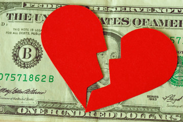 Broken heart on dollar banknote - Concept of love and money relationship