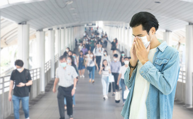 Double Exposure image of Asian worker or business man wearing surgical mask hands covered her mouth while coughing with blurred of crowed,Wuhan coronavirus (COVID-19) outbreak pandemic prevention.