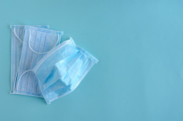 Medical masks lie on a blue background. Soft focus, horizontal image.