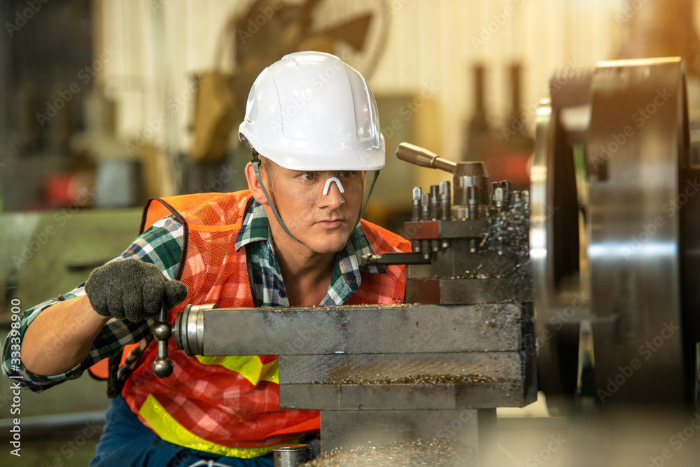 Aufkleber technician working on lathe spare part machine in iron manufacturing factory,works in a lathe concep