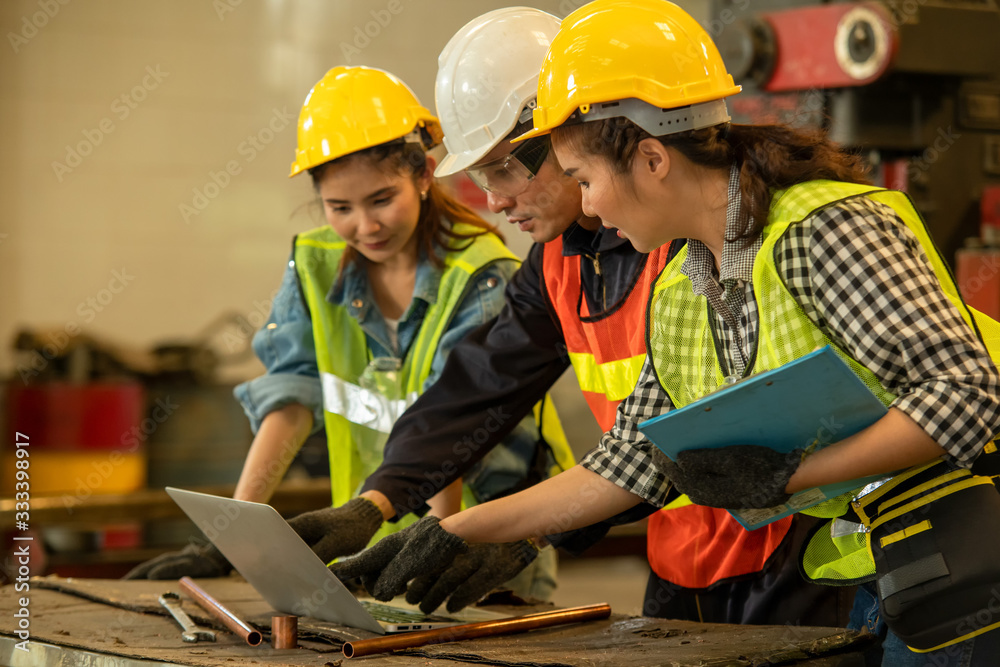 Poster mechanic working group in factory,technician wearing safety harness work together as team use laptop