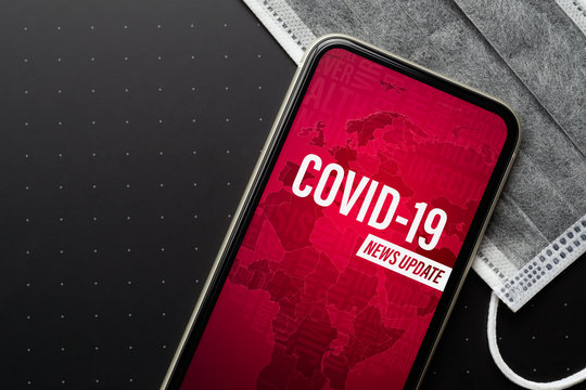Coronavirus or Covid-19 outbreak News Update background concept. Mockup mobile phone Coronavirus News with facial masks. Flat lay top view with copy space.