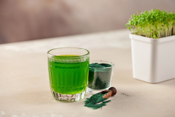 Glass of spirulina drink powder on table. Food and drink, dieting and nutrition concept.
