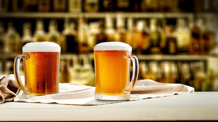 Two glasses of beer and bar background 