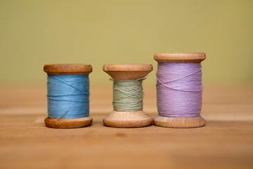Set of tailoring accessories. Close up of a stack of folded pink fabric, sewing scissors, and...