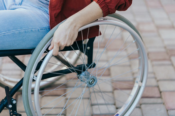 Close up of a young woman in a wheelchair while walking in a park on a sunny day. Recovery and...