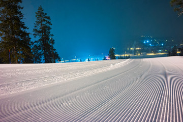 Ski slope in nights with lights from snowcats
