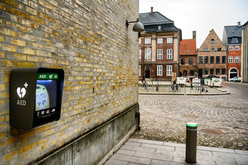 Wall mounted AED defibrillator in a public place. - obrazy, fototapety, plakaty