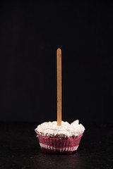 Strawberry ice cream popsicle lollies with whipped cream frozen in muffin molds on black background.
