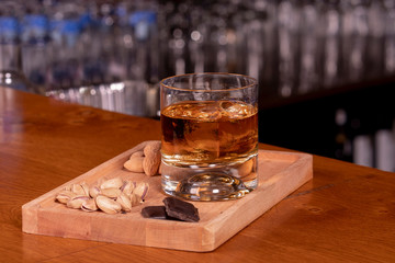 Glass of whiskey and nuts