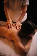 Young woman getting body massage in resort spa salon. Caucasian female with perfect body receiving hand massage in luxury spa center. Concept of luxury professional massage. Concept of body care.