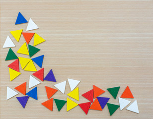 Various multi-colored geometric shapes on a wooden background. View from above. Background for text. Copy space