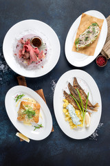 Several dishes in the frame of fried fish, sandwiches on a blue background