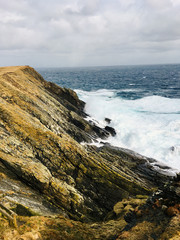 Beautiful view of cliffs at the coast of the Shetland Islands Scotland at a cloudy day with rough...