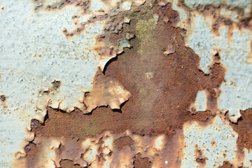 Rusty metal surface with flaking old white paint