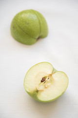 Slices of green healthy apple fruits on a white background