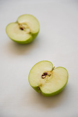 Slices of green healthy apple fruits on a white background