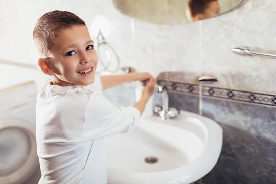 Cute boy washing his hands in bathroom. Protection against viruses and bacteria.