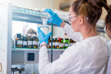 Beautiful young woman scientist in laboratory working. Young female scientist doing some research.