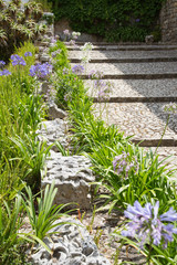 Garten- und Landschaftsbau: Steingarten in Hanglage mit Treppen aus Naturstein umrahmt von Reihen...