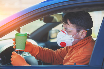 A man in medical face mask and safety glasses during an epidemic in the car