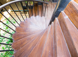 Wooden spiral staircase with the metal railing.