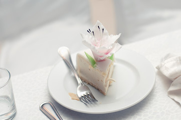 Wedding white cake with flower decoration on the table. Meal for the guests of the celebration. Table setting
