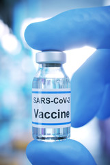 rubber glove with vaccine vial