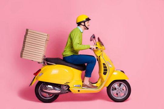 Profile side view of his he nice attractive cheerful cheery guy driving moped bringing pile stack pizza home order serving client isolated over pink pastel color background