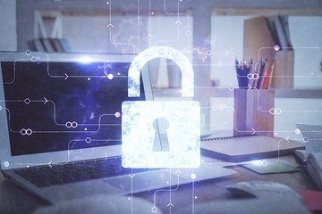 Double exposure of desktop with computer and lock icon hologram. Concept of data safety.