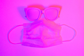 Medical protective mask and glasses, corona virus protection, doctor mask on neon background. Copy...