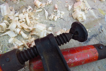 Old fashioned wood clamp on a workbench with wood shavings