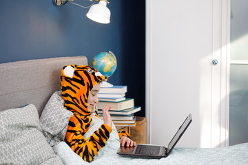 schoolboy studying at home using laptop during coronavirus pandemic. Online distance education during epidemics covid-19, covid quarantine concepte
