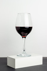 Glass of red wine on a white background. Minimalism. Design. Mock-up. Copy space.