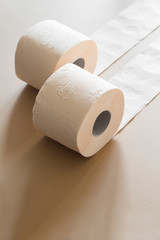 rolls of toilet paper peach beige color on beige background