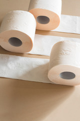 rolls of toilet paper peach beige color on beige background