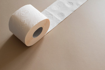 roll of toilet paper peach beige color on beige background