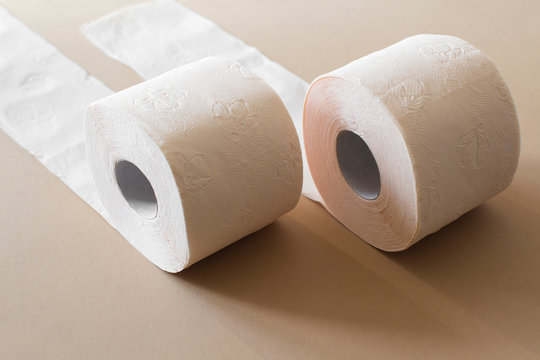 rolls of toilet paper peach beige color on beige background